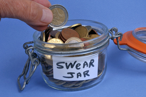 Putting two euros in a glass jar for swearing