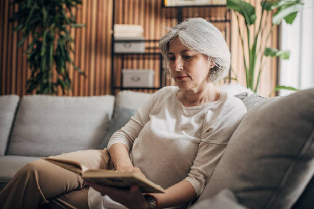 istock Mature woman reading at home 1587692465