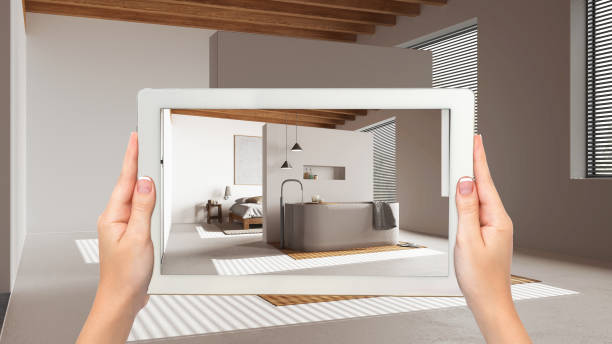 istock Augmented reality concept. Hand holding tablet with AR application used to simulate furniture and design products in empty wooden interior, japandi minimal bedroom and bathroom 1587712252