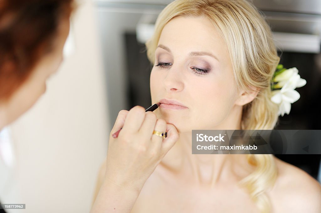 Young beautiful bride applying wedding make-up Young beautiful bride applying wedding make-up by make-up artist Adult Stock Photo