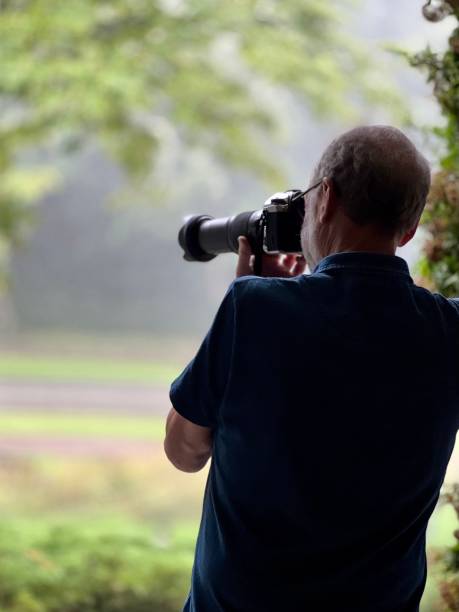 istock Senior man Photographing the rain 1587751479