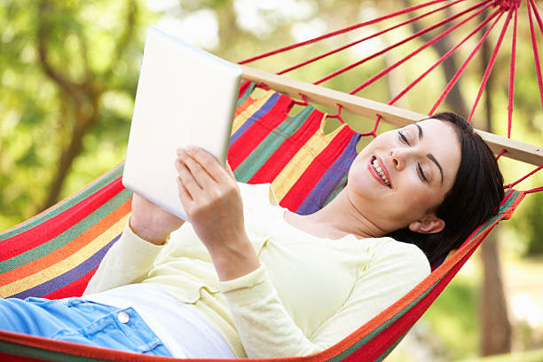 istock Woman Relaxing In Hammock With  E-Book 158775387