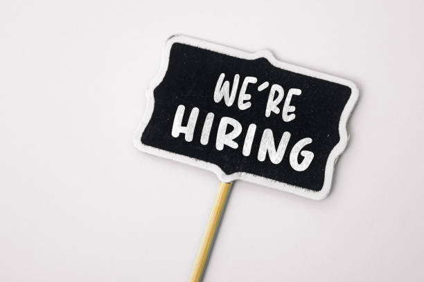 istock We're Hiring - text on a small chalkboard on a neutral background. Top view. Human resource concept, strategy, plan, planning 1587759776