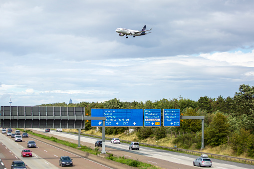 Frankfurt, Germany - August 01, 2023: A landing airplane of German airline Lufthansa at Frankfurt International airport. German highway A5 in the foreground