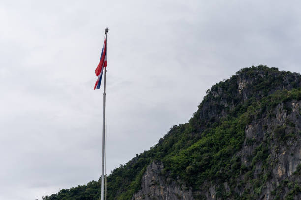 istock Thai flag pole in forest and mountains and blue sky 1587785358