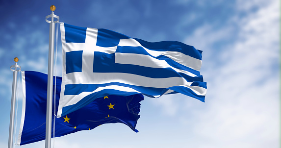 Flags of Greece and the European Union waving together on a clear day. Greece became a member of the European Union on 1981. 3d illustration render. International treaty and diplomacy