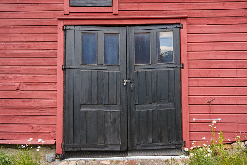 Old black wooden double doors in historical building in Porvoo, Finland.