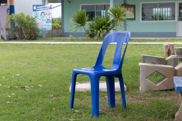 A blue chair is placed outdoors. on the green lawn