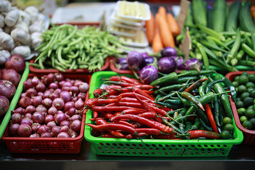 An array of multicolored fruits and vegetables showcased on a market stall in Penang, Malaysia, representing the concepts of healthy eating, vegetarianism, and veganism.