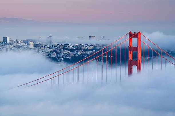 View of Golden Gate Bridge on a foggy day Golden Gate at dawn surrounded by fog san francisco california stock pictures, royalty-free photos & images