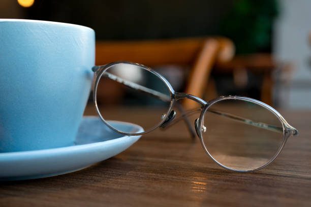 istock Coffee in blue cup on wooden table in cafe with lighting background 1587807840