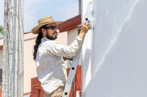 Man painting the outside of his house