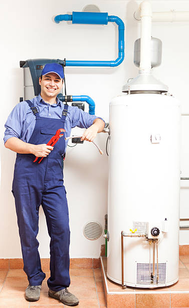 uśmiechająca się hydraulik w pracy - water heater boiler installing repairing zdjęcia i obrazy z banku zdjęć