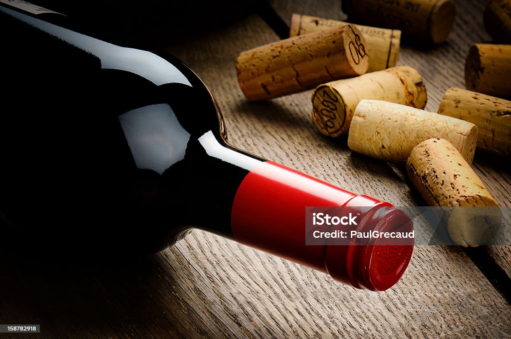Bottle of red wine and corks Bottle of red wine and corks on wooden table Alcohol - Drink Stock Photo