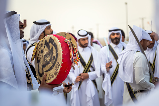A group of Saudi Arabs performing traditional saudi arabian dance in Abqaiq Desert Safari Festival Saudi Arabia 10th January 2020. Selective focused on the subject background blurred.
