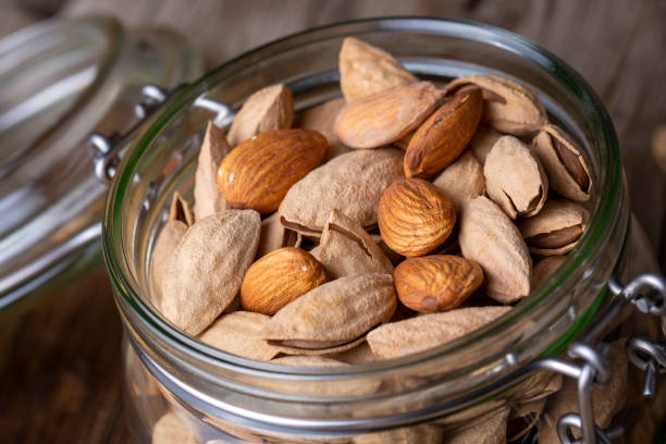 istock Almonds in jar on wooden background 1587839706