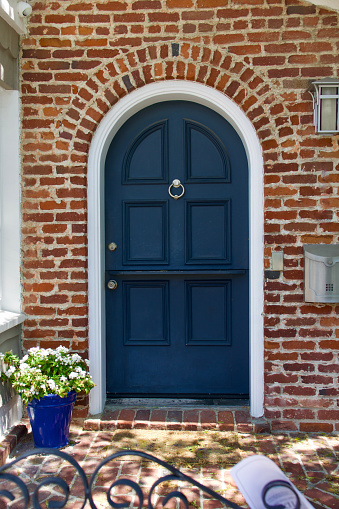 Vintage brick cottage with arched wood front door