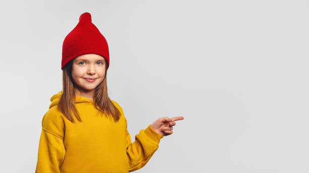 istock Hipster cute little kid pointing on free empty white space for your advertising 1587850596