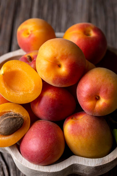 istock Fresh apricot fruit on the wooden background 1587857443