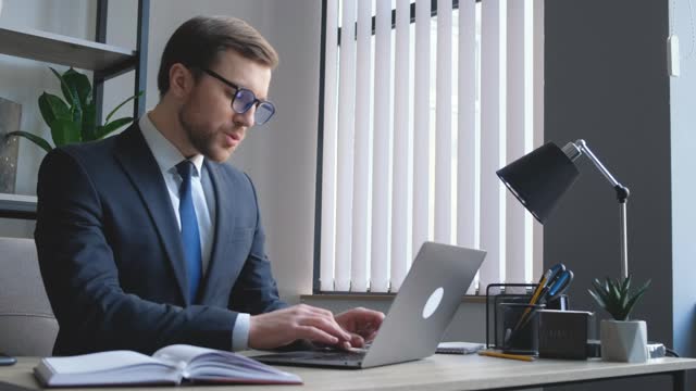 Young attractive focused manager of European appearance working at computer.