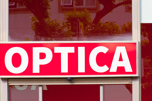 Optometrist store red sign over doorway.  Galicia, Spain. Spanish language
