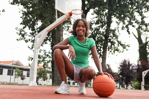 Girl playing basketball. About 12 years old, African female.