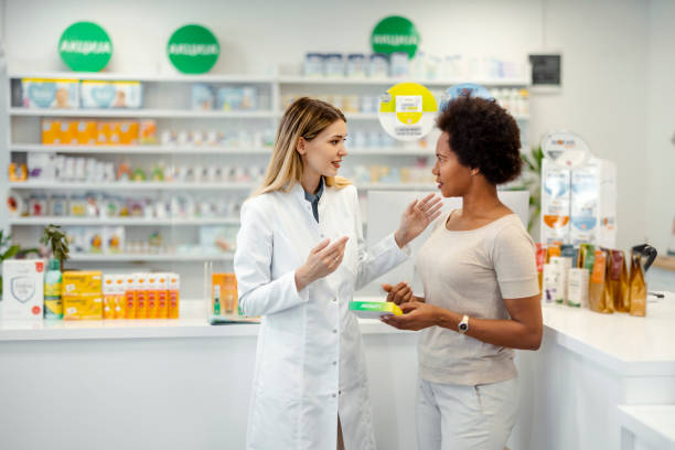 istock Caucasian Pharmacist Helping African American Female Customer 1587895507