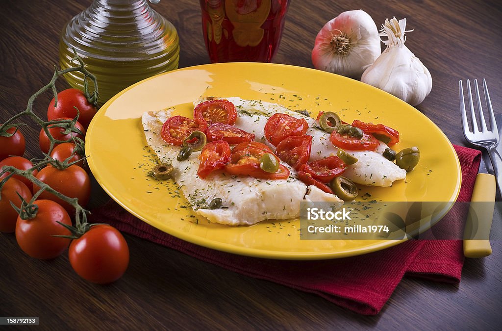 Fish with cherry tomatoes and olive. Cod Stock Photo