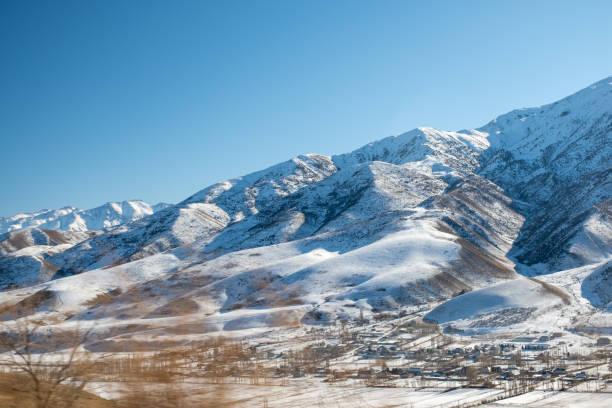панорамный вид на заснеженные горы. зима. красивое чистое голубое небо при дневном свете. впечатляющий вид на горные вершины - kazakhstan glacier snow mountain view стоковые фото и изображения