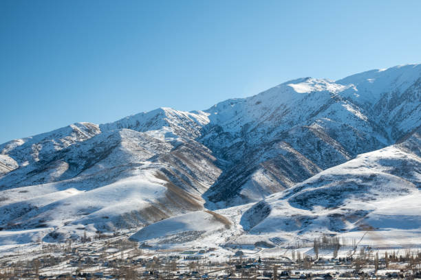 высокие горы под снегом. панорамный вид на заснеженные горы. зима. красивое чистое голубое небо при дневном свете. впечатляющий вид на горны - kazakhstan glacier snow mountain view стоковые фото и изображения