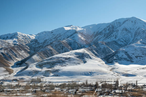 высокие горы под снегом зимой. панорамный вид на заснеженные горы. зима. красивое чистое голубое небо при дневном свете. впечатляющий вид на - kazakhstan glacier snow mountain view стоковые фото и изображения