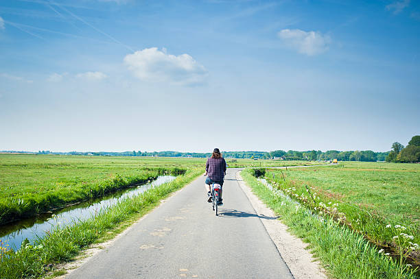Man Rides A Bicycle In The Country, Netherlands stock photo