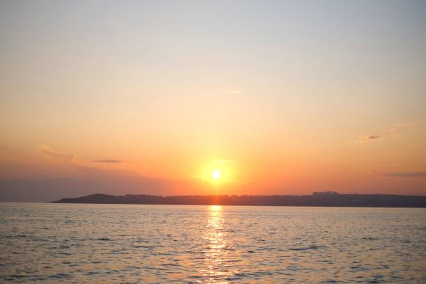 istock Pastel sunset over the ocean in a cloudy sky 1587948645
