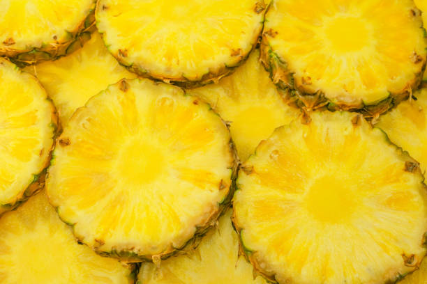 istock Pineapple juicy yellow slices as a background. 1587989408