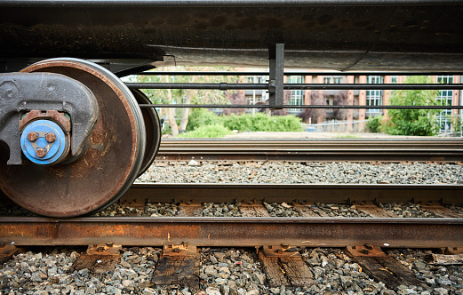 Close-up of freight train resting on rusty iron railroad tracks at a depot in a city