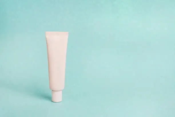 Photo of mockup of beauty fashion cosmetic makeup tube cream or lotion product, blue background, skin care
