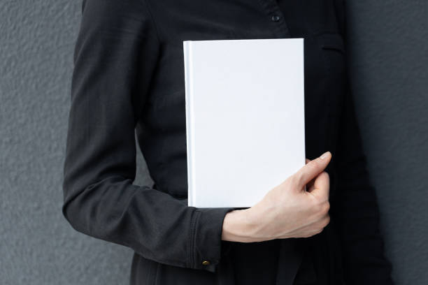 istock White book cover in woman's hands. Book cover for mock up 1588045227