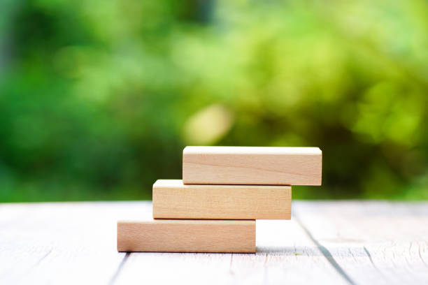 3 stacking rectangle empty wooden blocks on table with green natural blur background for own customer text or letters. Idea of environment, energy or business concept. Front view, banner copy space.