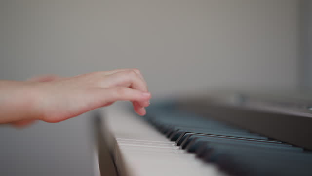 Girl performs musical composition on piano looking at sheet music