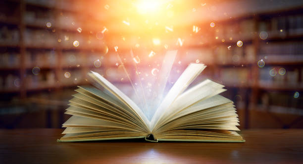 Book With Magic Lights And Bright Letters In Defocused Library
