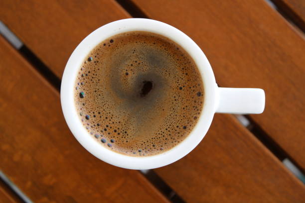 istock Cup of coffee on wooden table 1588081297