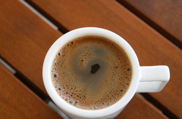 istock Cup of coffee on wooden table 1588088116