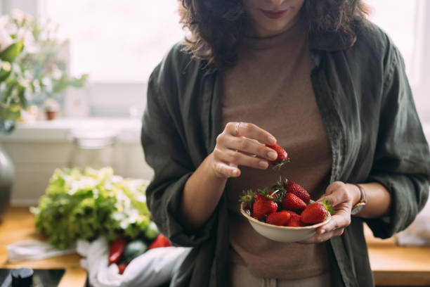 istock An Unrecognizable Beautiful Woman Eating Strawberries 1588090776