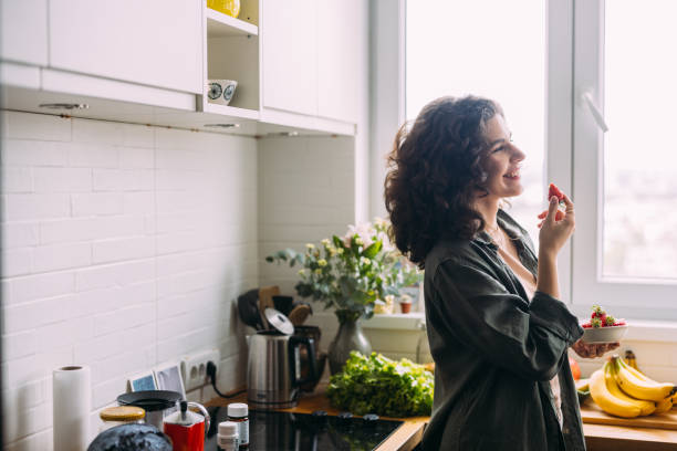 istock A Happy Beautiful Woman Looking Away While Eating Strawberries 1588090785