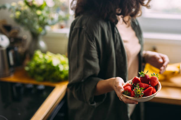 istock An Unrecognizable Beautiful Woman Eating Strawberries 1588090789