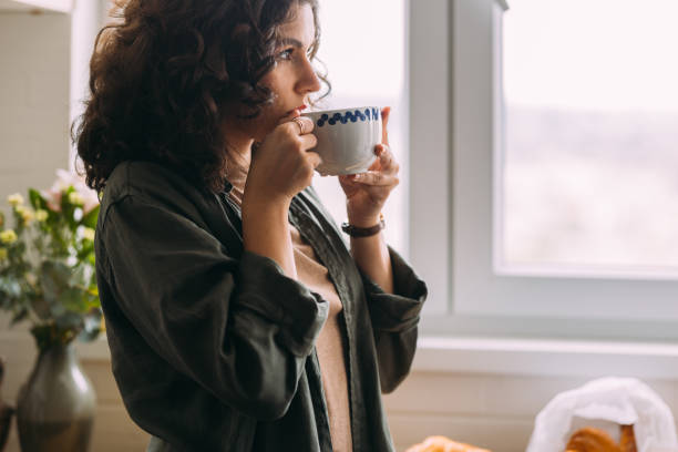 A Serious Beautiful Woman Looking Away While Drinking Tea
