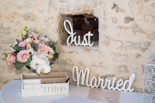 Just married in handwritting decoration, brick wall and table, bouquet of roses