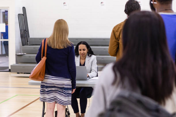 istock Diverse group of unrecognizable voters wait in line to get their ballots 1588098826