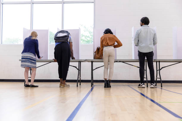 istock Multiracial group of voters stand quietly at voting booths 1588098883
