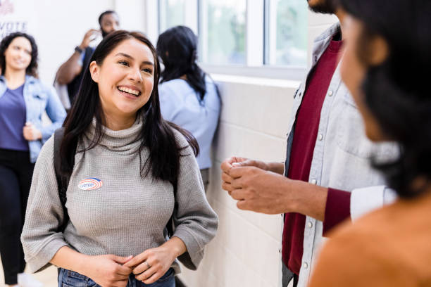 une jeune étudiante adulte parle avec ses amis tout en faisant la queue - election presidential candidate usa bipartisan photos et images de collection